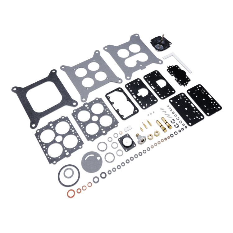 A complete mechanical gasket and seal kit laid out on a white background, including multiple black and silver gaskets, several black rubber O-rings, and small brass fasteners.