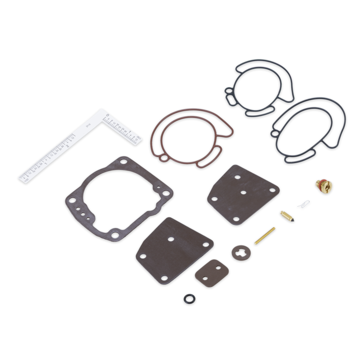A flat lay of an engine gasket kit on a white background, including multiple black and brown gaskets, several small metal fasteners, washers, and a white ruler for scale.