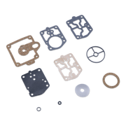 A set of flat mechanical gaskets, seals, and rings laid out on a plain white background. The pieces include several dark gray rubber gaskets, one tan gasket, one light beige gasket, a tan ring, a gray circular piece, a translucent white disc, and two small black O-rings.