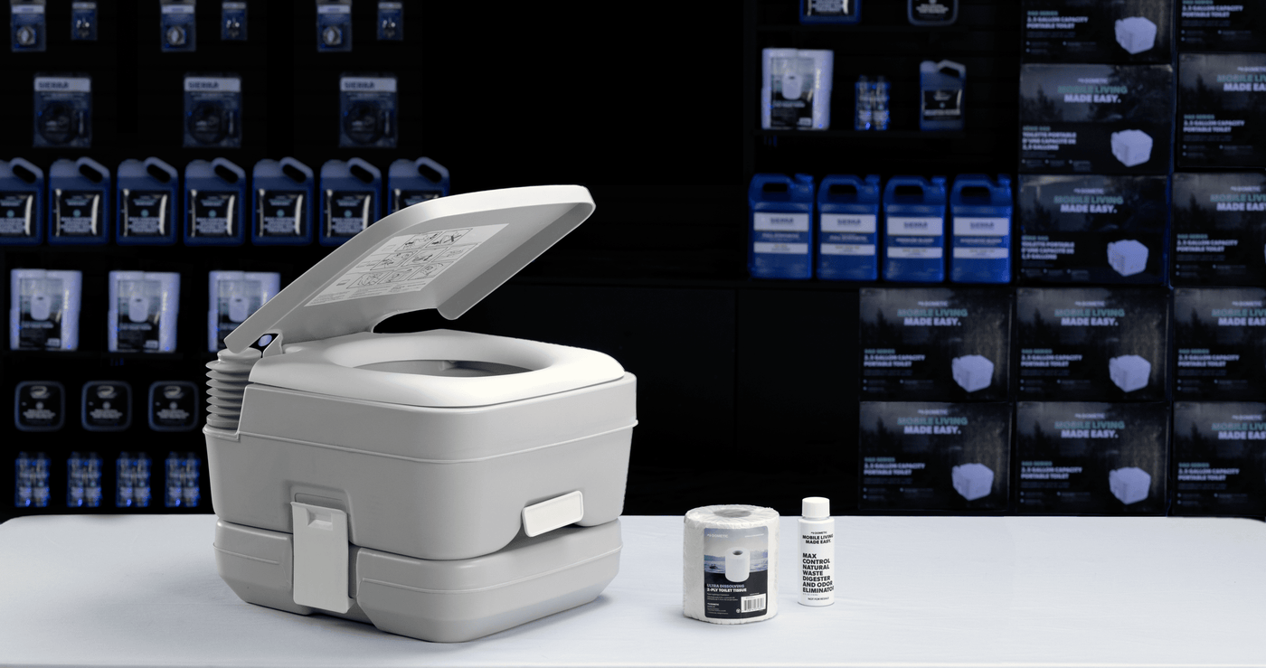 A Dometic 962 portable  toilet, toilet paper, and tank treatment with other Sierra and Dometic products in the background