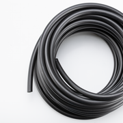 A coiled roll of black rubber tubing on a plain white background.