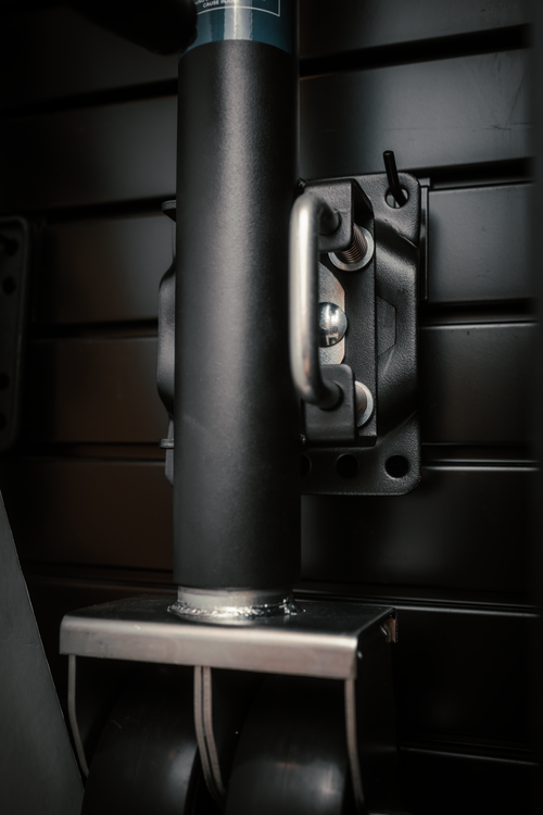 A closeup of a dual wheel Sierra trailer jack on a dark brown display rack