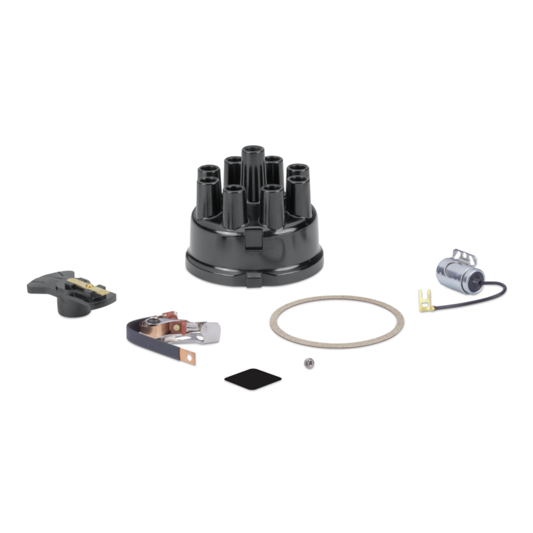A black distributor engine part kit with various components including a black plastic distributor body, a black terminal cover, a silver ignition coil, a beige rubber gasket, and small hardware, displayed on a clean white background.