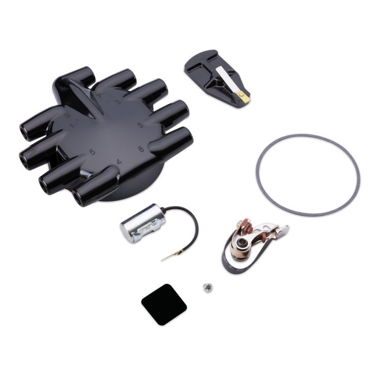 Tune up kit components, including a black distributor, a black ignition switch, a silver coil, a copper ignition switch, a black rubber gasket, and small mounting hardware, arranged on a plain white background.