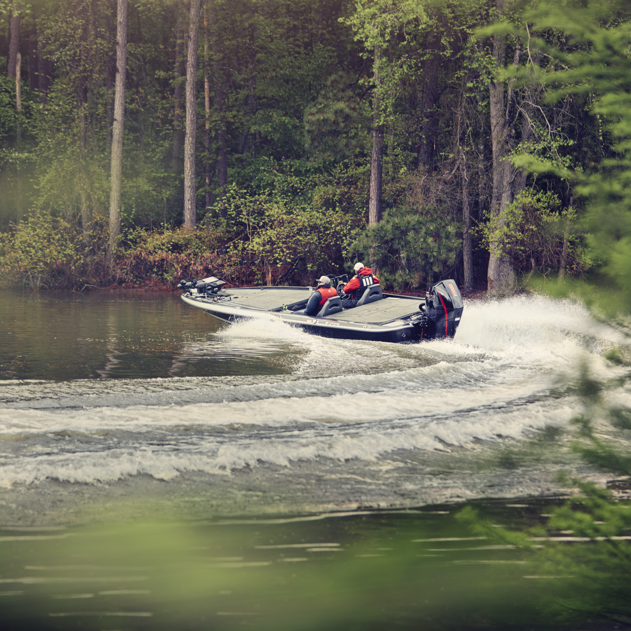 A bass boat with a Mercury outboard engine taking a hard left turn on a lake