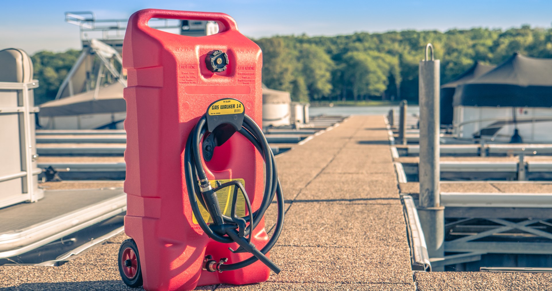 Sierra's red portable gas caddy standing upright on two wheels on a boat dock