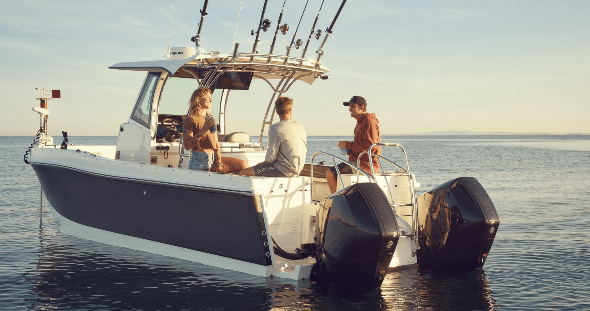 Three people on a blue and white center console boat with twin engines in open water